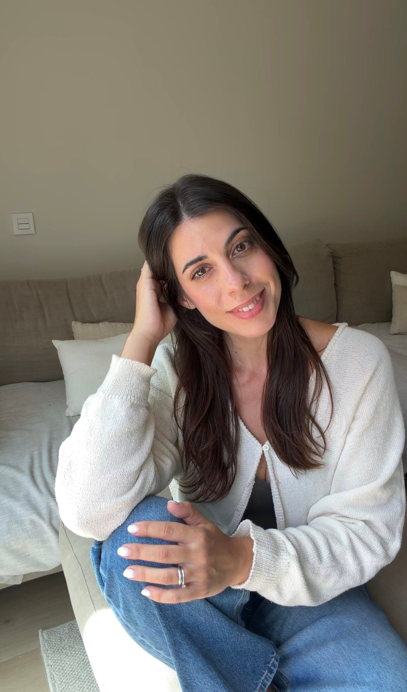 Sandra Serensi sonriendo, sentada en un sofá